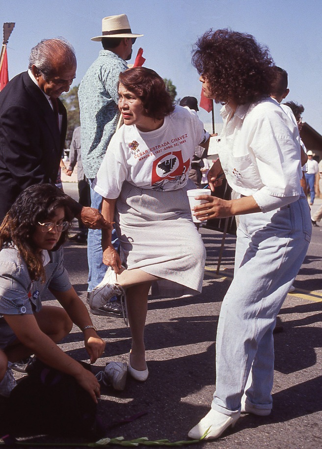 In this photo which has never been published until now, Dolores Huerta steps out of her dress shoes and into tennis shoes to participate in "The Last March" at the funeral of her United Farm Workers co-founder Cesar Chavez.